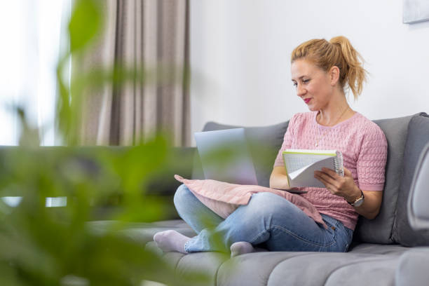 istock Happy woman with laptop and notebook 1598721163