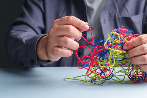 El hombre intenta arreglar el problema de las cuerdas enredadas, concepto de psicoterapia photo