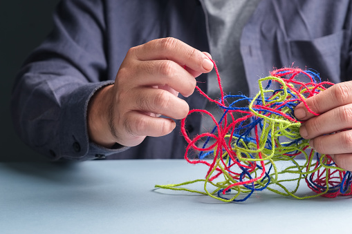 Man tries to fix the problem of tangled ropes, psychotherapy concept