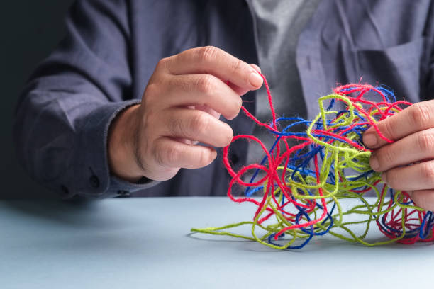 Man tries to fix the problem of tangled ropes, psychotherapy concept Closeup man try to fix the problem of tangled ropes, psychotherapy concept, complicated problem complexity stock pictures, royalty-free photos & images