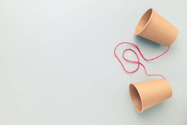 istock Paper cups phone with a red string on an empty clear background, 1598743996