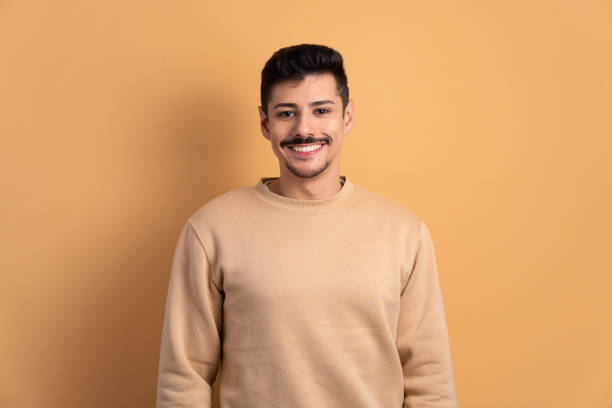 istock man smiling and looking at camera in beige background 1598753243