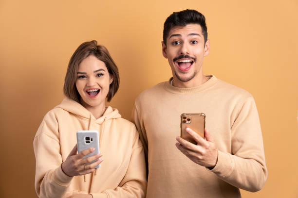istock surprised couple looking at mobile cell phone 1598753248