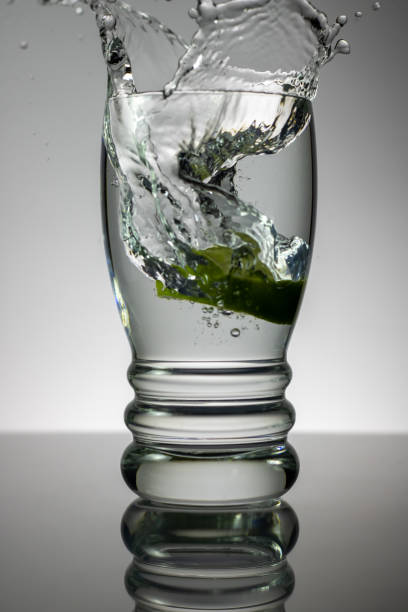 A glass of ice water with a lemon slice.