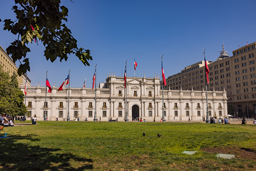 View from Plaza de la Constitucion, facade of Palacio de La Moneda in the government quarter of the metropolis Santiago de Chile, South America, April, 13th, 2023