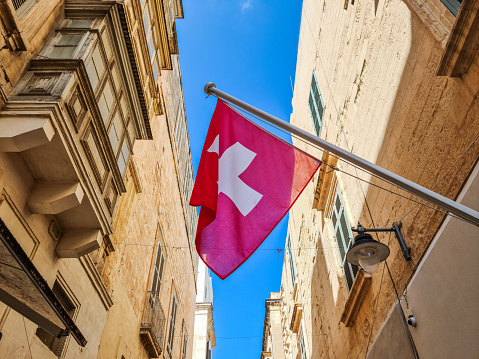 A flag of Switzerland on the street in Malta.