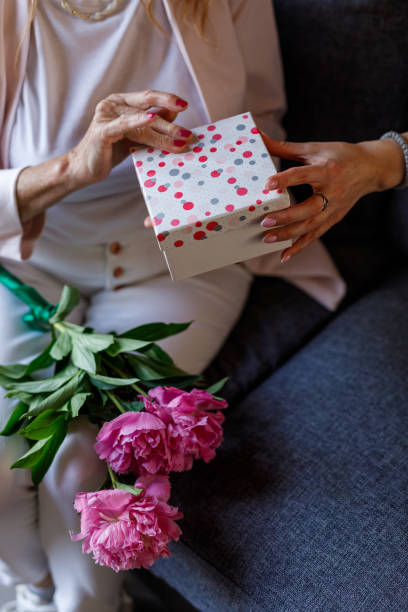istock Woman opening a gift box her daughter surprised her with 1598817418