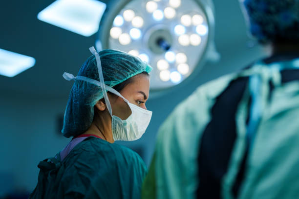 Surgeon and Nurses at Surgery Room Part of a Series: Surgeon and Nurses at Surgery Room surgery stock pictures, royalty-free photos & images