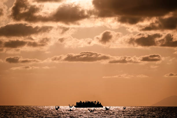 istock Ship with refugees on board requiring help. Sea with people in the water asking for help. Migrants crossing the sea 1598818547