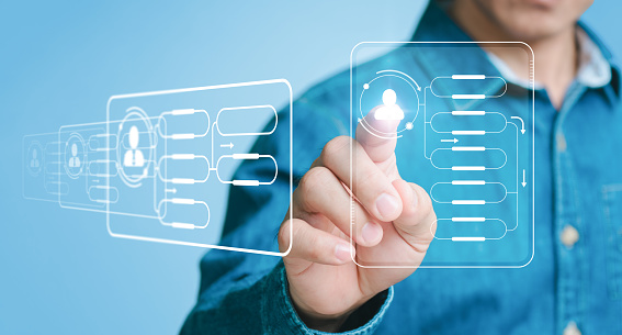 Automation of corporate processes and workflows using flowcharts. On a visual screen, a businessman points to a chart and configures processing management.