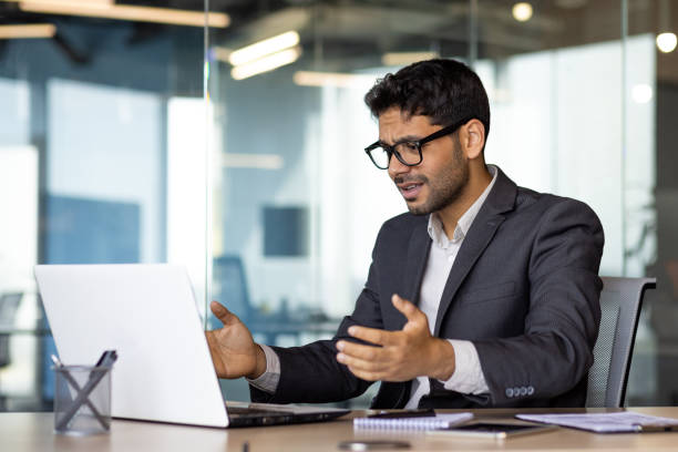 istock Frustrated and upset hispanic businessman at workplace, man got online rejection error on laptop, unhappy with results inside office in business suit boss 1598829391