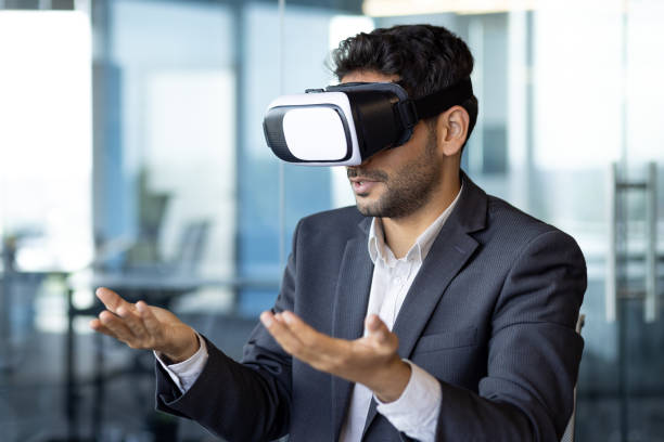 istock Young arab businessman talking online remotely, using vr glasses, man on remote meeting with colleagues in metaverse, sitting inside office 1598829931