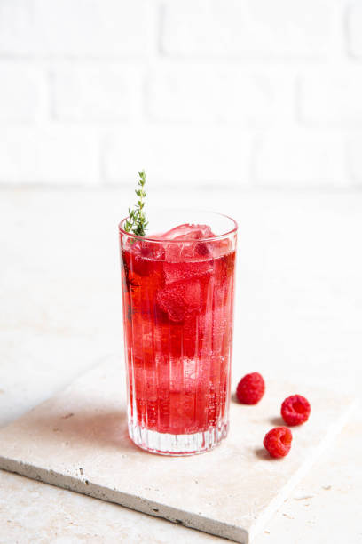 red raspberry gin cocktail longdrink limonade soda drink avec baies et thym sur le comptoir lumineux de la cuisine - raspberry soda photos et images de collection
