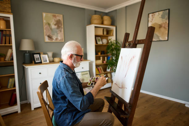 istock Elderly man painting on a canvas at home 1598862608
