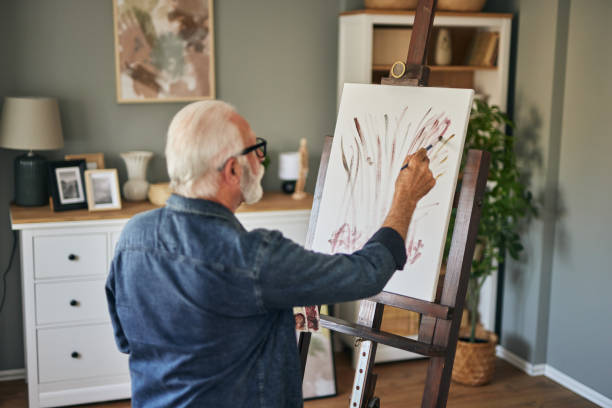 istock Elderly man painting on a canvas at home 1598863349