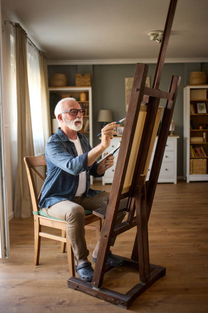 istock Elderly man painting on a canvas at home 1598864310