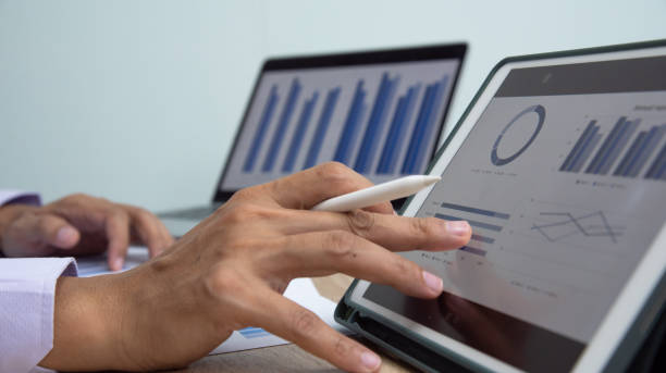 istock Businessman working at office with digital tablet, laptop computer, smart phone. Professional investor connection internet application online. Businessmen review annual company report. 1598874731