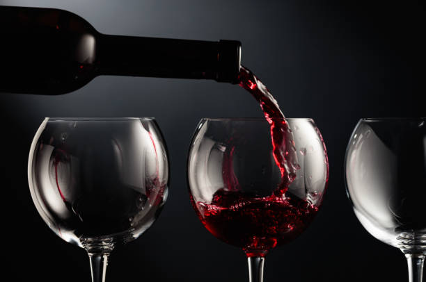 istock Pouring red wine into a wine glass. 1598875932