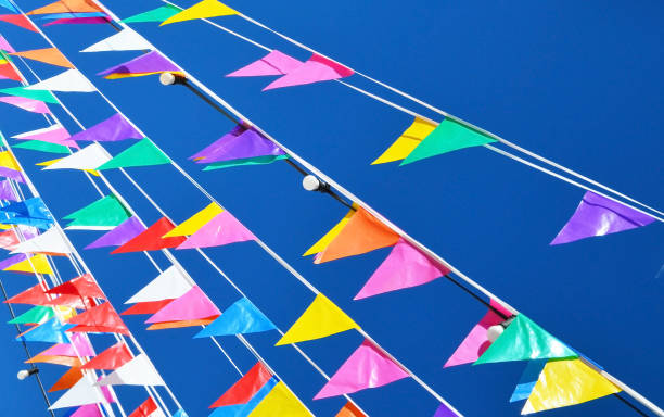 istock Multicolored triangular small flags to celebration party against blue sky.Street holiday concept for design. 1598884154