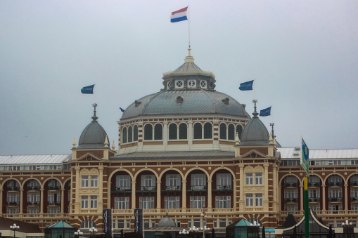 Scheveningen, Netherlands - July, 2023: Famous Kurhaus hotel at Scheveningen Beach (The Hague) on a rainy and windy day in summer.