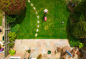 Aerial view of man mowing the lawn in his back garden