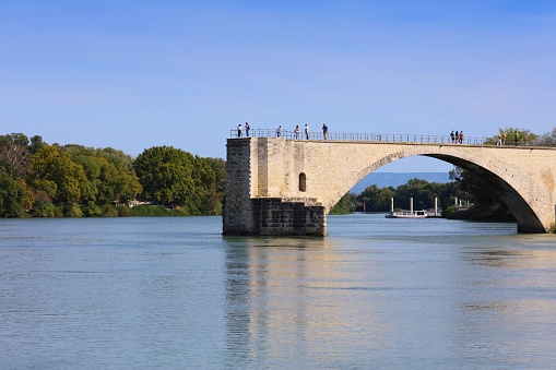 People visit Avignon town Pont Saint-Benezet (Bridge of Saint Benezet) in France. Historic centre of Avignon is a UNESCO World Heritage Site.
