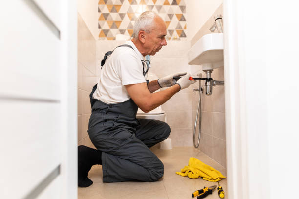 istock The plumber wearing in working suit fixes the siphon sink using the wrench 1598931520