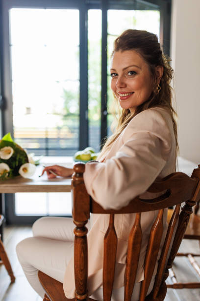 istock Woman smiling at camera after writing a greeting card 1598974207