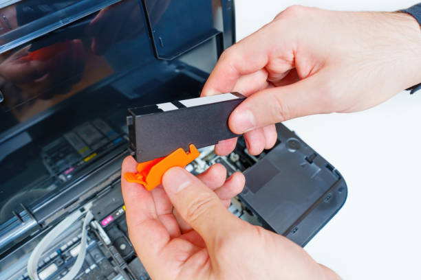 istock Removing Plastic Cap from the Ink Nozzle of a Printer Cartridge 1598979719