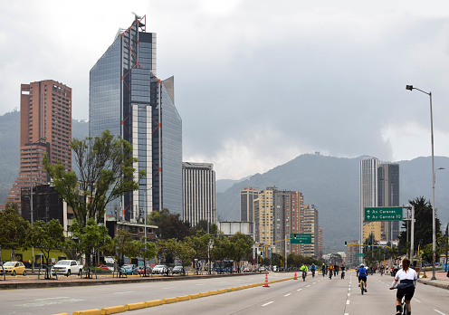 Cycleway on 26th street in Bogota, Colombia. In the background the urban skyline with the atrium tower and the colpatria tower. Cycling Sunday on the avenue