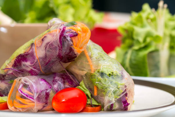 Close up of Fresh spring roll on disk placing together with other fresh vegetable