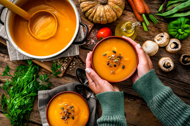 추수감사절 식사를 위해 호박 수프 한 그릇을 들고 있는 여자 - thanksgiving vegetarian food pumpkin soup 뉴스 사진 이미지