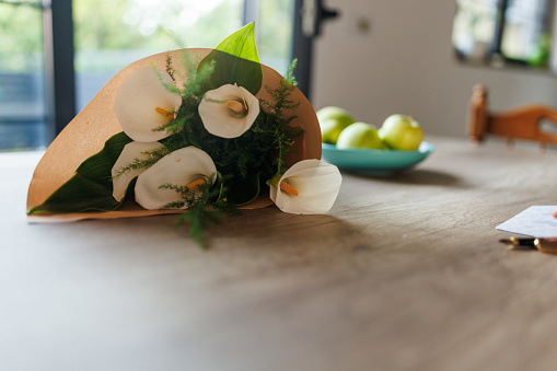 Close up shot of beautiful bouquet of calla lily flowers on the table.