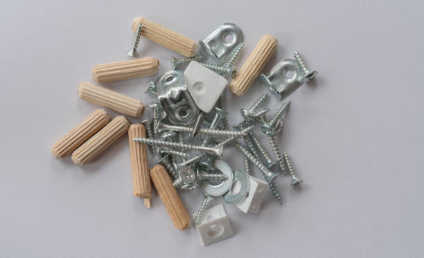Assortment Of Screws, Dowels, Nails And Other DIY Equipment On Plain Grey Background