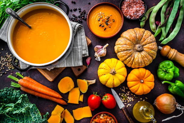 istock Ingredients for pumpkin soup preparation on dark table 1599013457