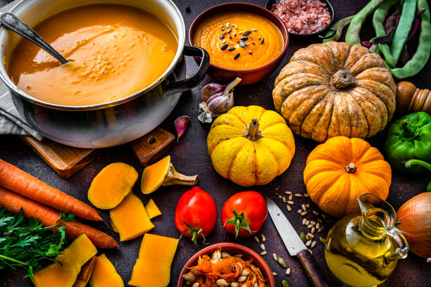 Ingredients for pumpkin soup preparation on dark table