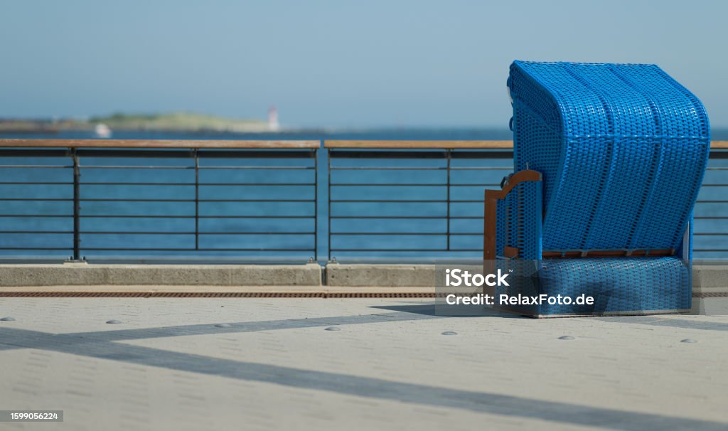 Rear view on Blue outdoor chair on pier at sea Camera: Nikon Z8 - 45MP-Sensor / Location: Island Helgoland, Schleswig-Holstein, Germany. Back Of Chair Stock Photo