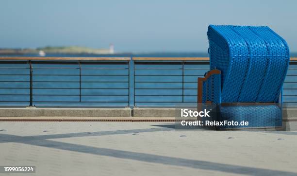 Rear View On Blue Outdoor Chair On Pier At Sea Stock Photo - Download Image Now - Back Of Chair, Blue, Chair