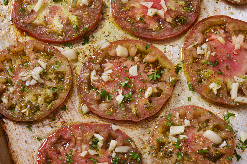 Heirloom Tomatoes Marinated in Olive Oil , Garlic and Italian Seasoning ready for Roasting