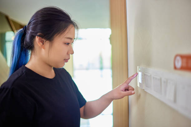 istock woman turning on central air conditioner 1599081709