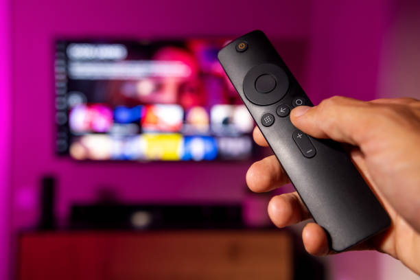istock remote control in hand with tv in background. streaming service, content on demand. watching online television at home 1599083766