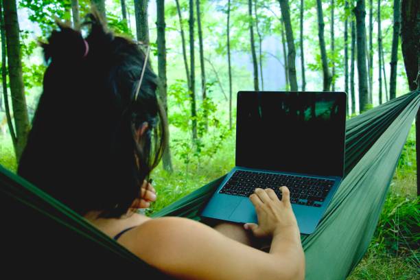 istock Girl check her pc in a hammock 1599088517