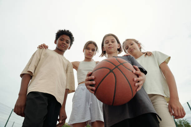 Low angle of four serious intercultural boys and girls in activewear stock photo