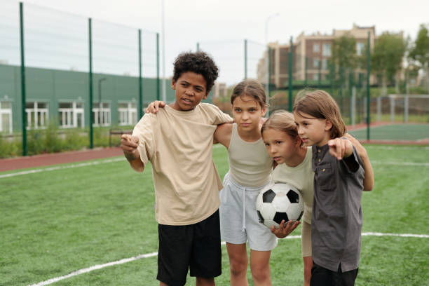 istock Cute schoolboy pointing forwards while explaining his classmates rules of game 1599099500