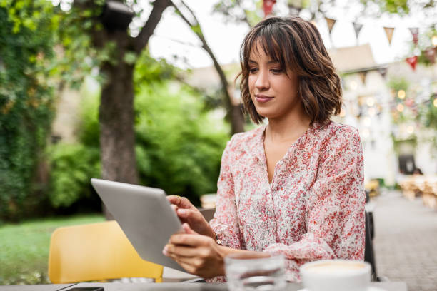 istock Attractive Woman Embracing Technology in the Cafe 1599101731