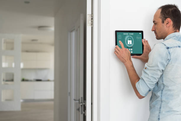 istock Young electrician installing security alarm on wall 1599115463