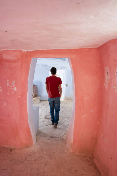 istock Man with red shirt walking inside abandoned Argueda caves, in Spain 1599130229