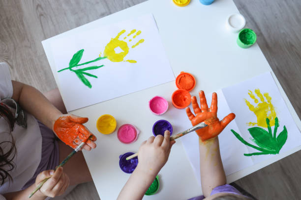 Children's drawing workshop, happy children make handprints with paint.