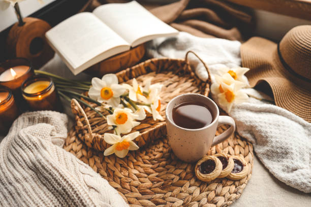 istock Spring still life, cup of tea, candles, open book and hat 1599156145