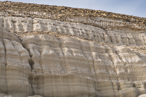 Layered formations in limestone hills due to water in the Kazakh steppe, desert mineral formations with texture